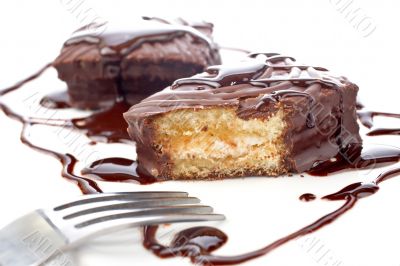 Two chocolate cupcakes with syrup and the fork