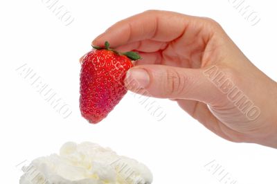 Woman hand strawberry over cream
