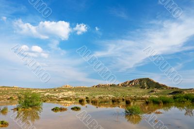 Hill over the blue sky and the lake