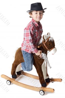 adorable boy playing cowboys with a wood horse