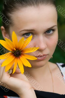 The young girl with a yellow flower close up