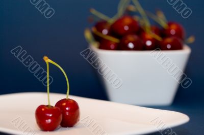 two cherries on a white plate