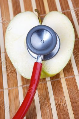stethoscope and apple with a heart shape