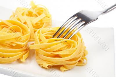 Uncooked pasta nests and fork