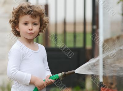 adorable boy watering the plants