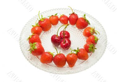 Strawberries and cherries on glass dish, isolated