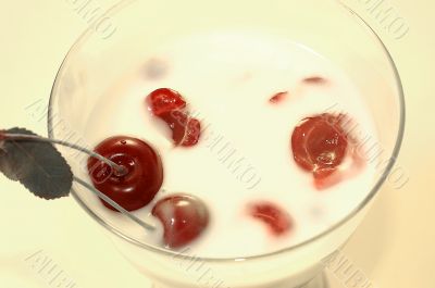 Yoghurt with a cherry on a yellow background