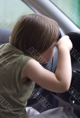 Girl looking through steering wheel