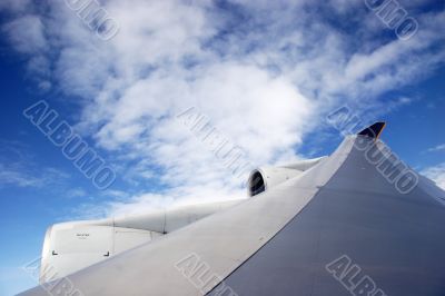 Plane wing with white clouds