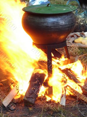cooking with black pot on opened wood fire