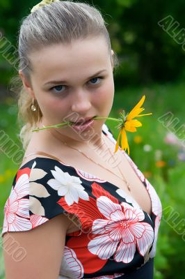 The young girl with a yellow flower close up
