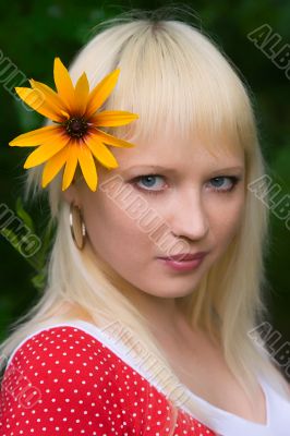 The young girl with a yellow flower close up
