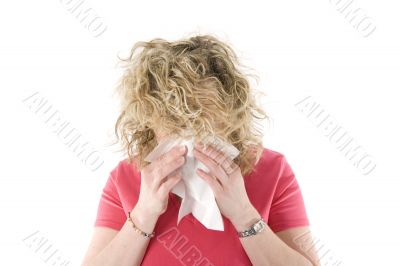 Young blond girl sneezing in the handkerchief