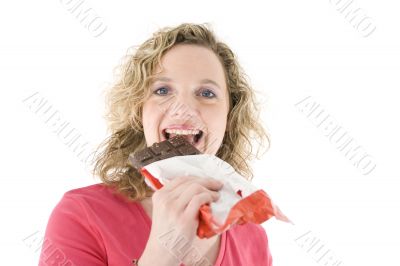 Young blond woman eats chocolate