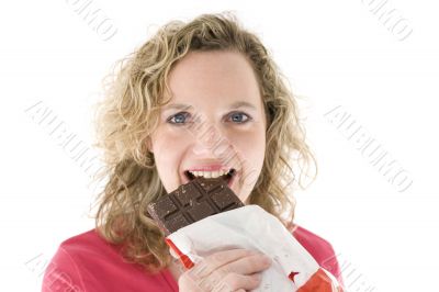 Young blond woman eats chocolate