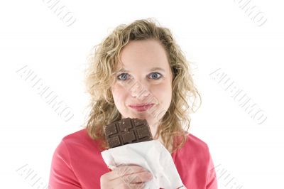 Young blond woman eats chocolate