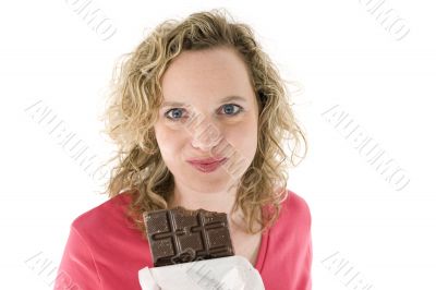 Young blond woman eats chocolate