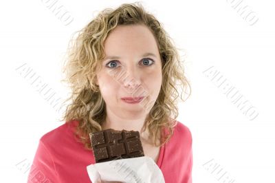 Young blond woman eats chocolate