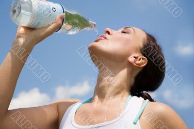 Young woman trinking water outdoors