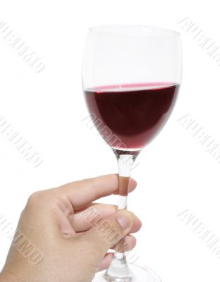 Woman`s hand holding a glass of red wine