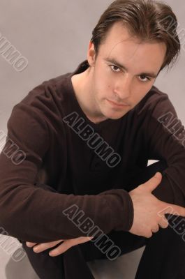 Sitting young the man in dark clothes