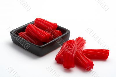 Pieces of red licorice on black bowl