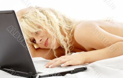 portrait of blond laying in bed with laptop