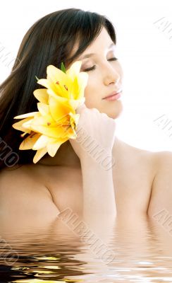 brunette with yellow lily flowers in water
