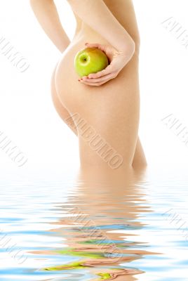 naked woman with green apple in water