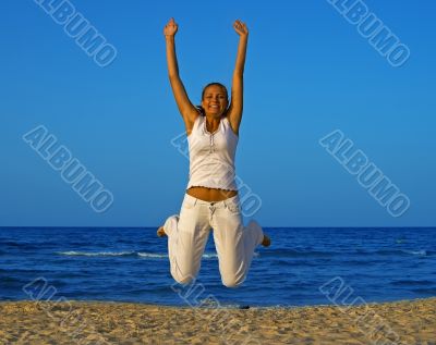Smiling girl jump at the beach