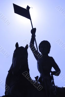 Silhouettee of a statue against blue