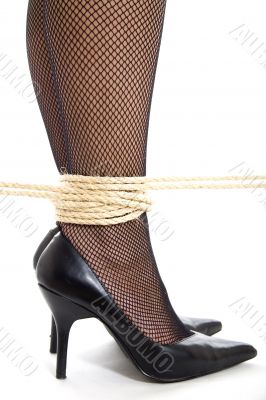 A woman`s ankles, bound with rope