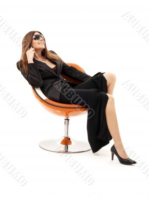 businesswoman with phone in orange chair