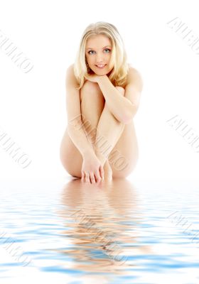naked blond sitting in blue water