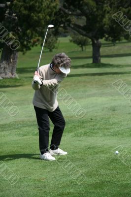 Woman golfer teeing off