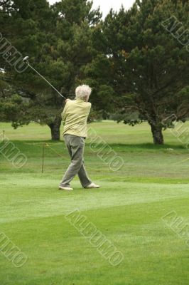Woman golfer teeing off