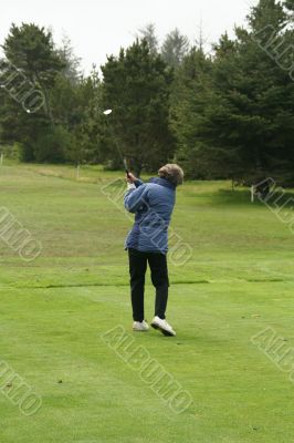 Woman golfer teeing off