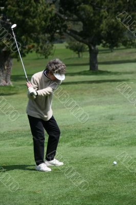 Woman golfer teeing off