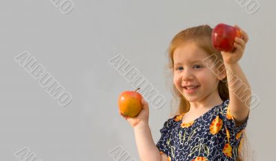 Baby girl with two apples (Focus on yellow apple)