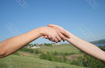 Handshake and cloudy sky