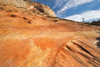 Orange striped slope and plumose clouds
