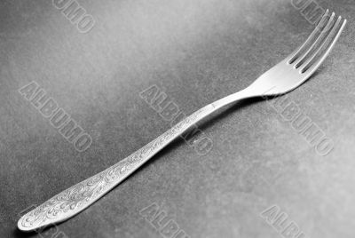 silver dinner fork on a grey background