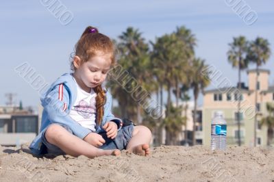 Child playing with sand on a beach