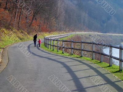Long lane on the lakeside with two people