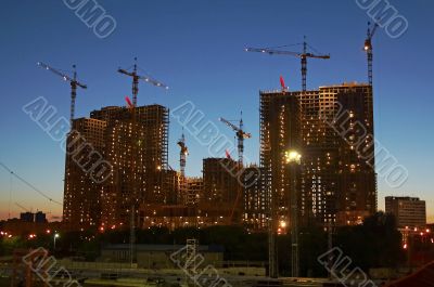 Building with cranes at evening