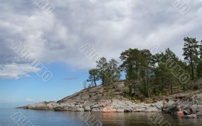 Rocky island with pines on tranquil lake