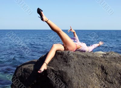 The sexual girl lays on a stone