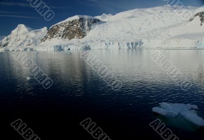 Mountains & glaciers reflected in calm ocean