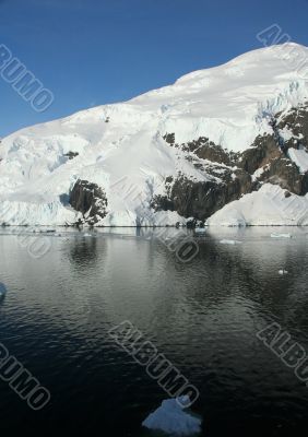 Mountains & glaciers reflected in calm ocean
