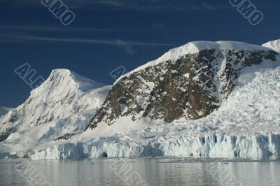 Mountains & glaciers reflected in calm ocean